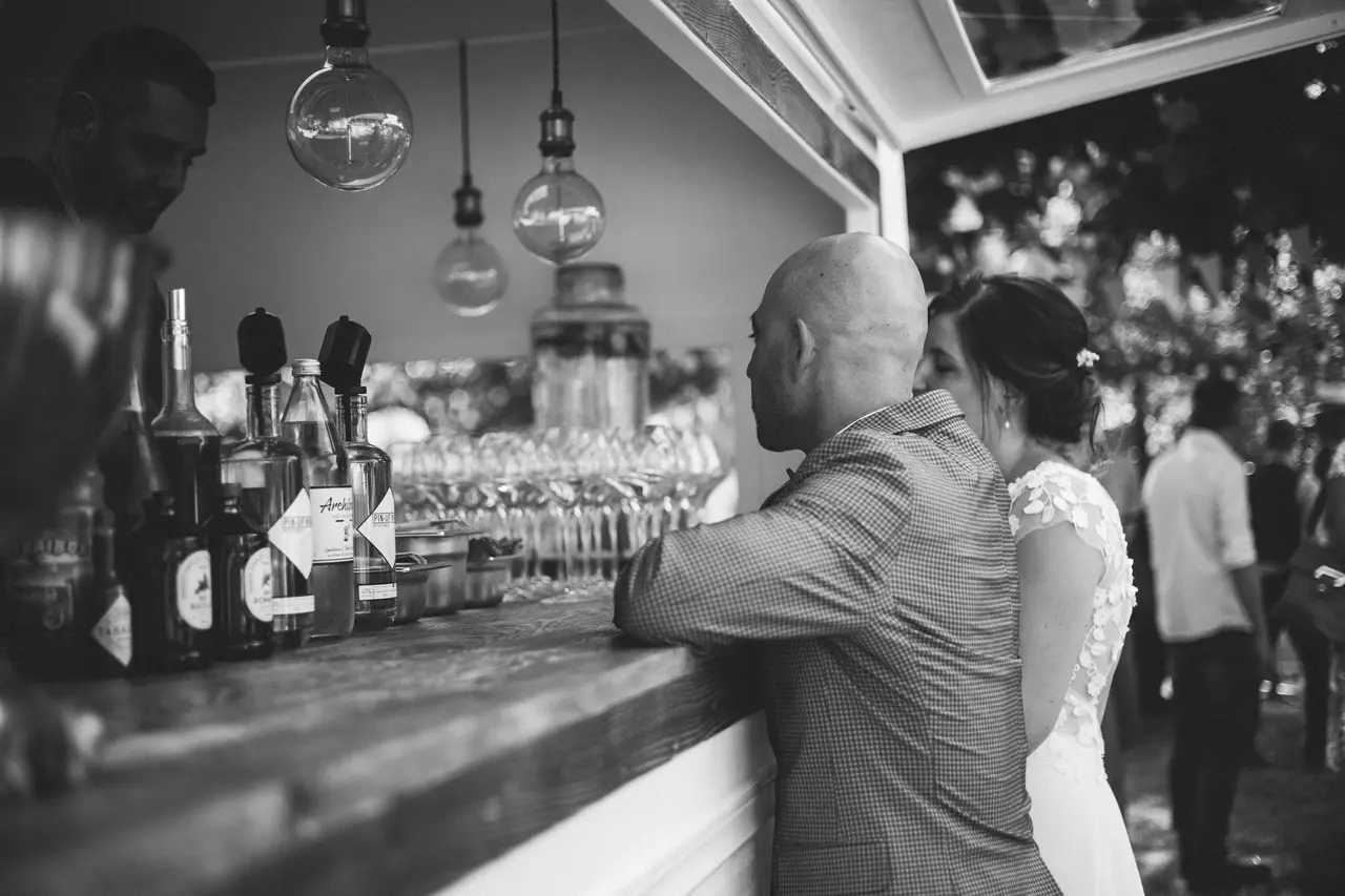 Photo de couple de mariés de profil devant la caravane drink